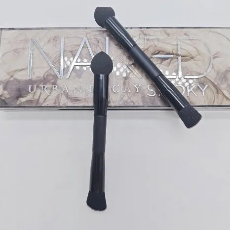 Elegant black double-headed makeup brush with a concealer brush and angled miter sponge on a wooden handle.