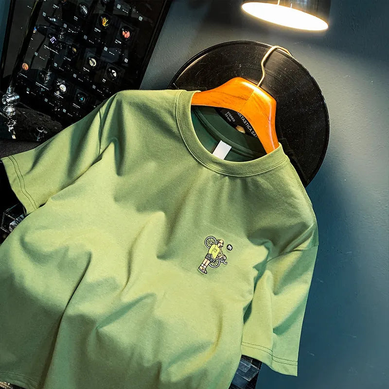 Green men's oversized t-shirt with a printed graphic design and short sleeves on a hanger