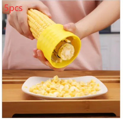 Yellow corn-shaped manual corn grinder thresher kitchen gadget on a wooden surface