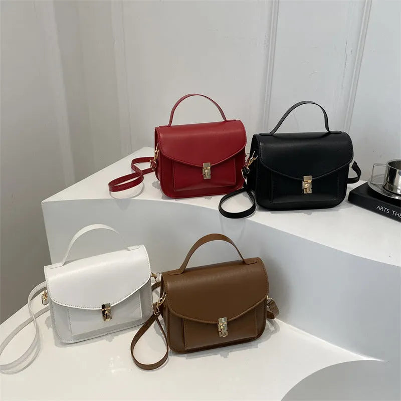 Horizontal square black PU messenger bag with a front sandwich pocket and visible sewing lines.