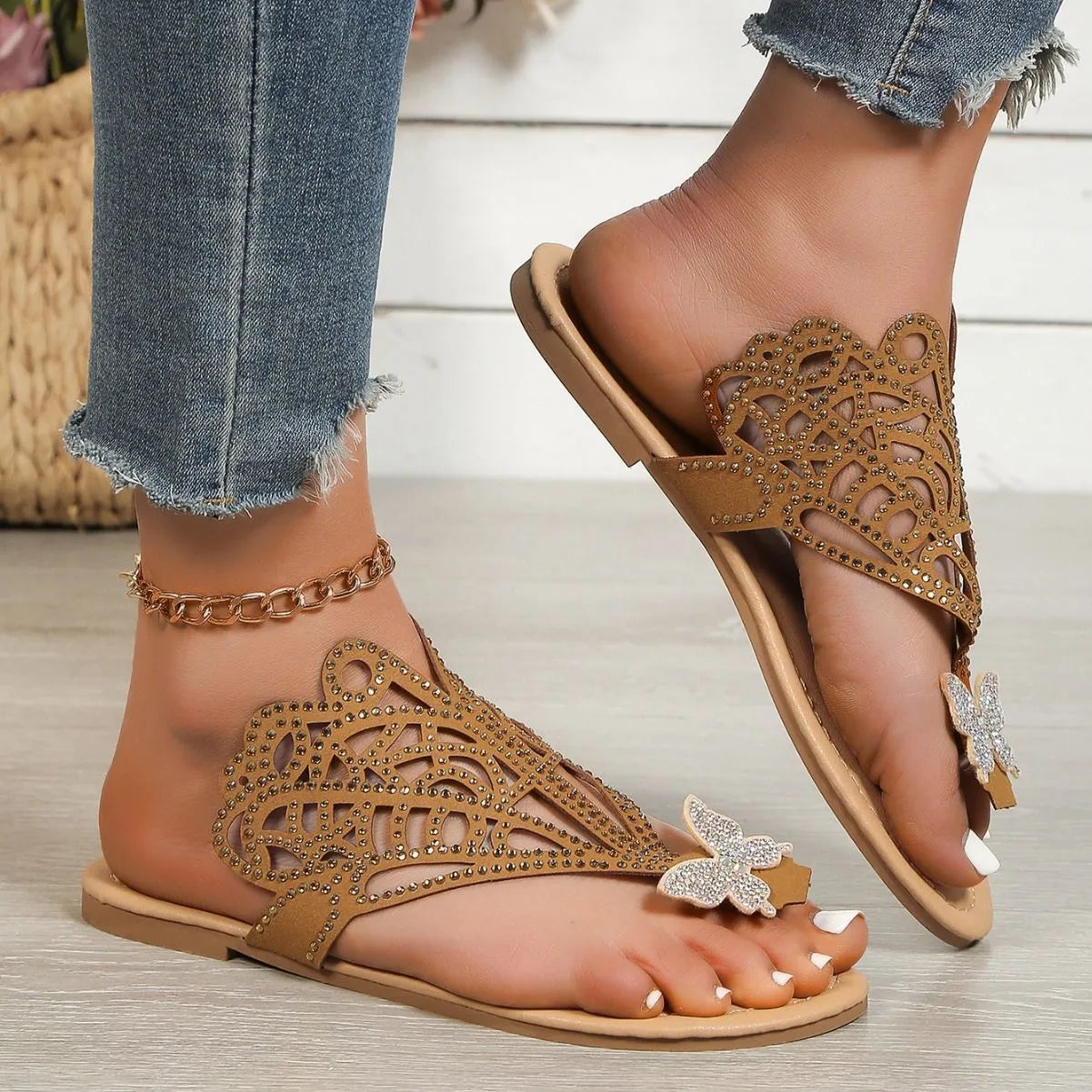 Women's black flip-toe sandals with rhinestone details on the hollow-out PU upper and a flat rubber sole.
