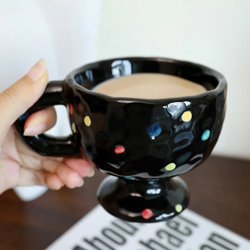 A handmade, irregularly shaped ceramic mug in a solid colour, shown on a table.