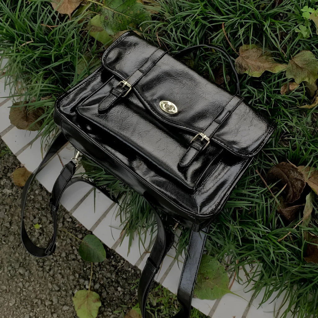 Women's black college style messenger bag made from oil wax PU leather showing front view