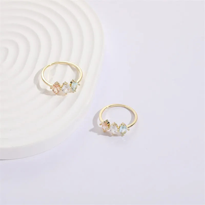 Geometric triangle ring with tricolour zircon birthstone in gold electroplated finish.