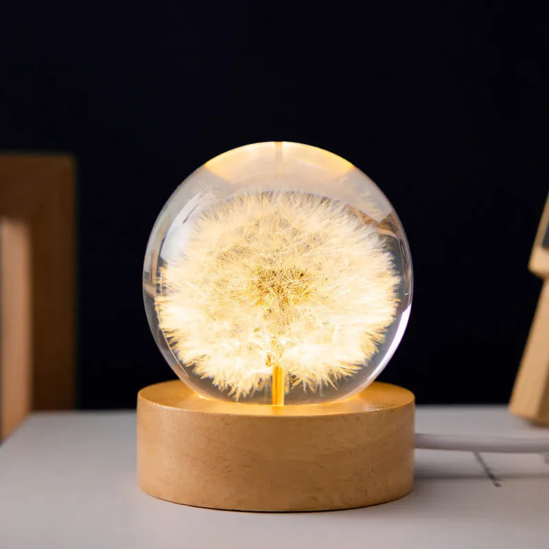 Preserved dandelion inside a glowing resin crystal ball night light on a beech wood stand.