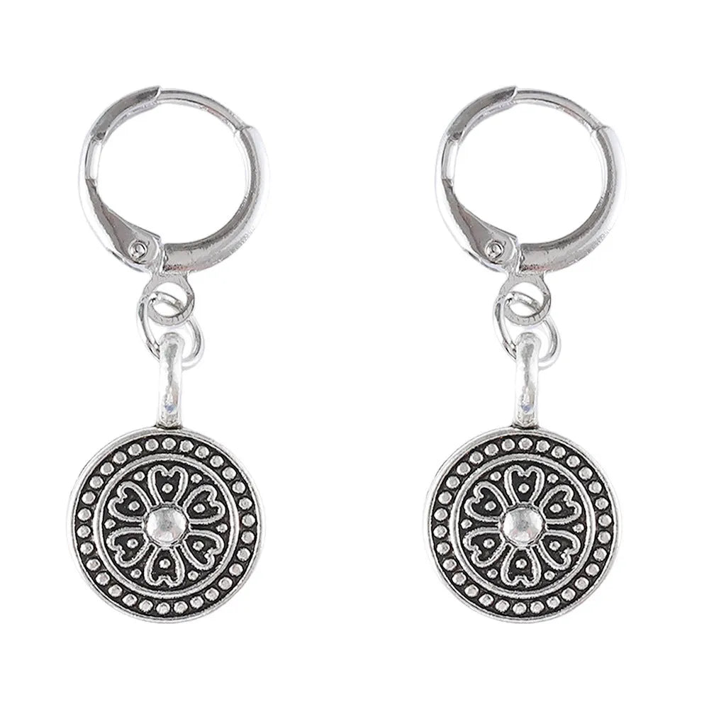 Close-up of a pair of distressed geometric bohemian earrings with a round print, in zinc alloy with electroplated colour.