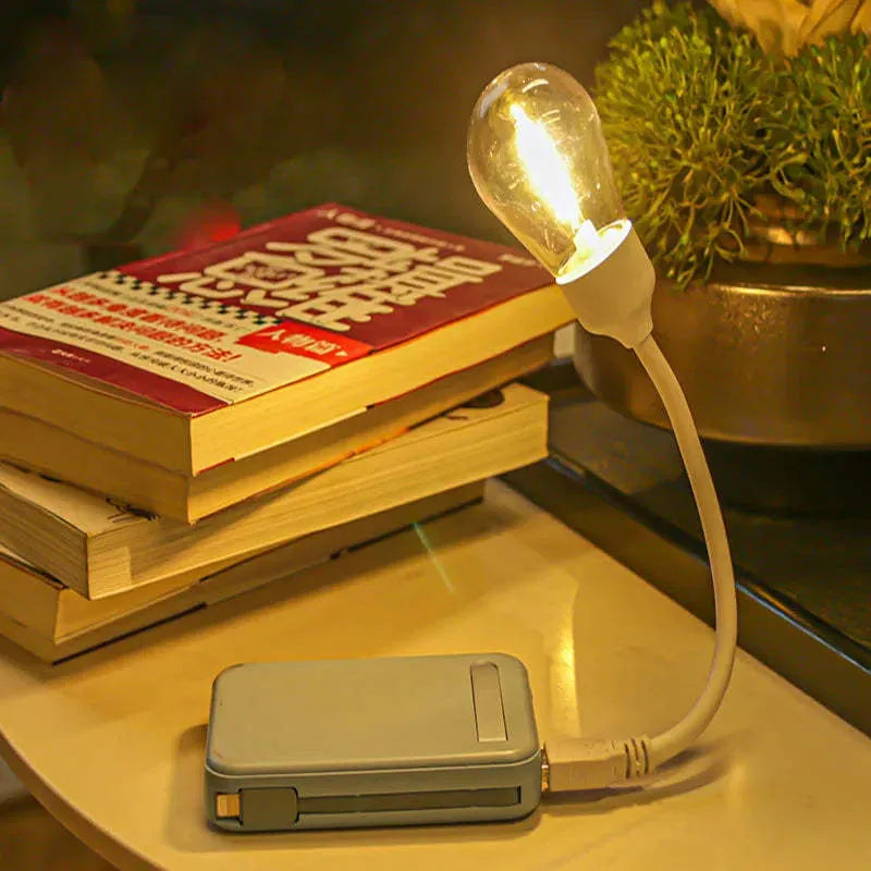 Folding USB rechargeable night light with warm white tungsten bulb, shown in open position.