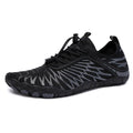 White and black lace-up casual trainers with rubber soles on a plain background