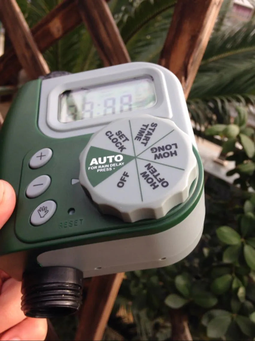 Green digital garden hose timer with copper connector and programmable watering display