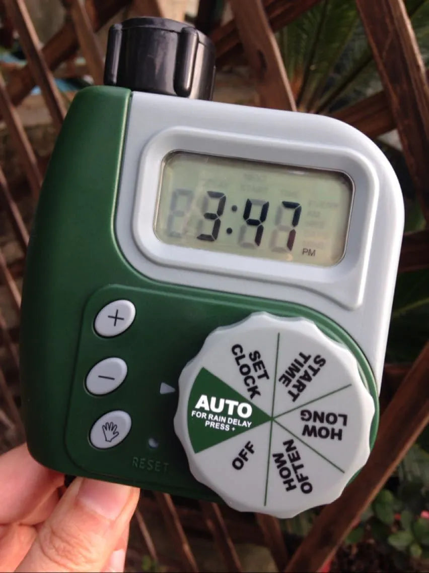 Green digital garden hose timer with copper connector and programmable watering display