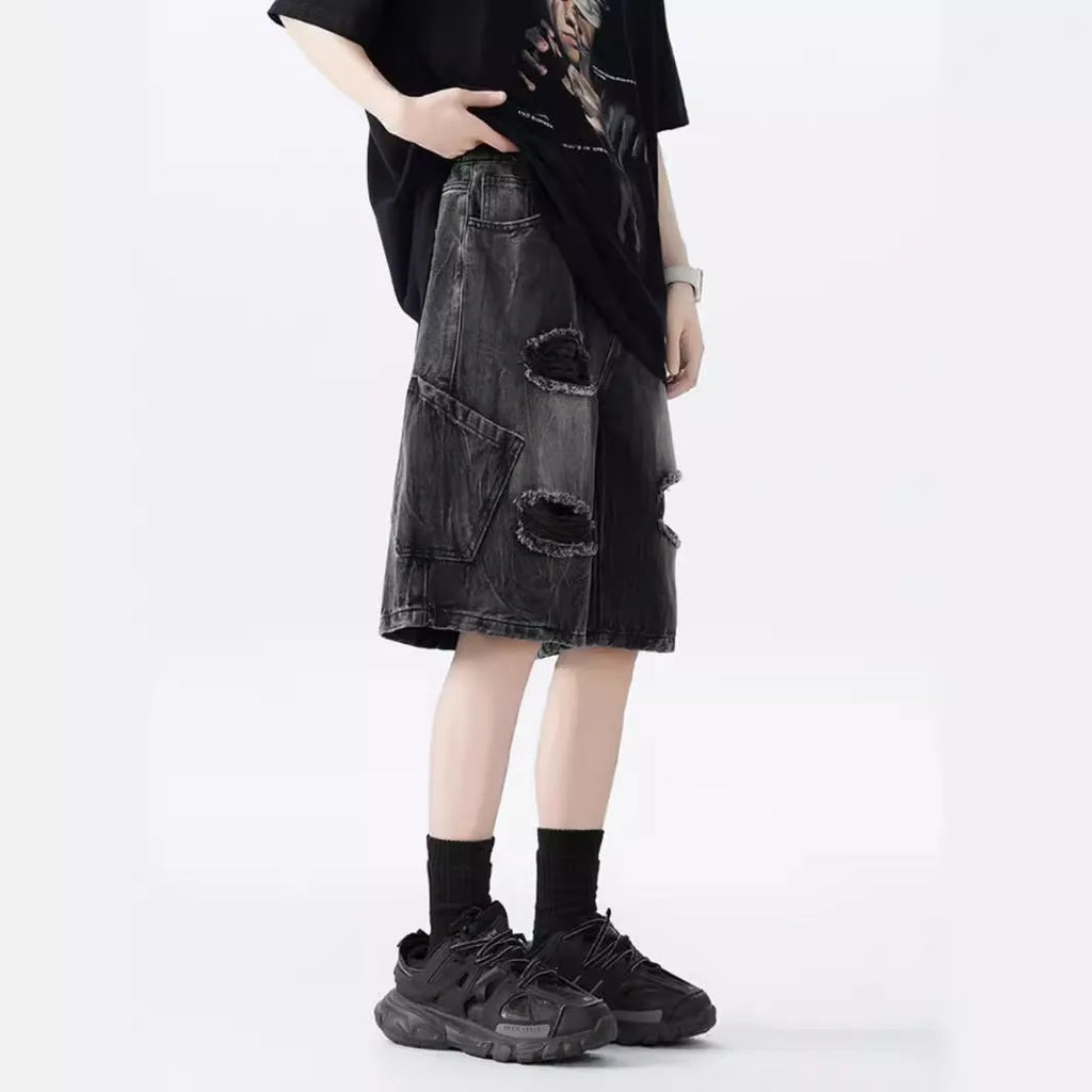 Model wearing loose-fit washed denim shorts with ripped details in blue.