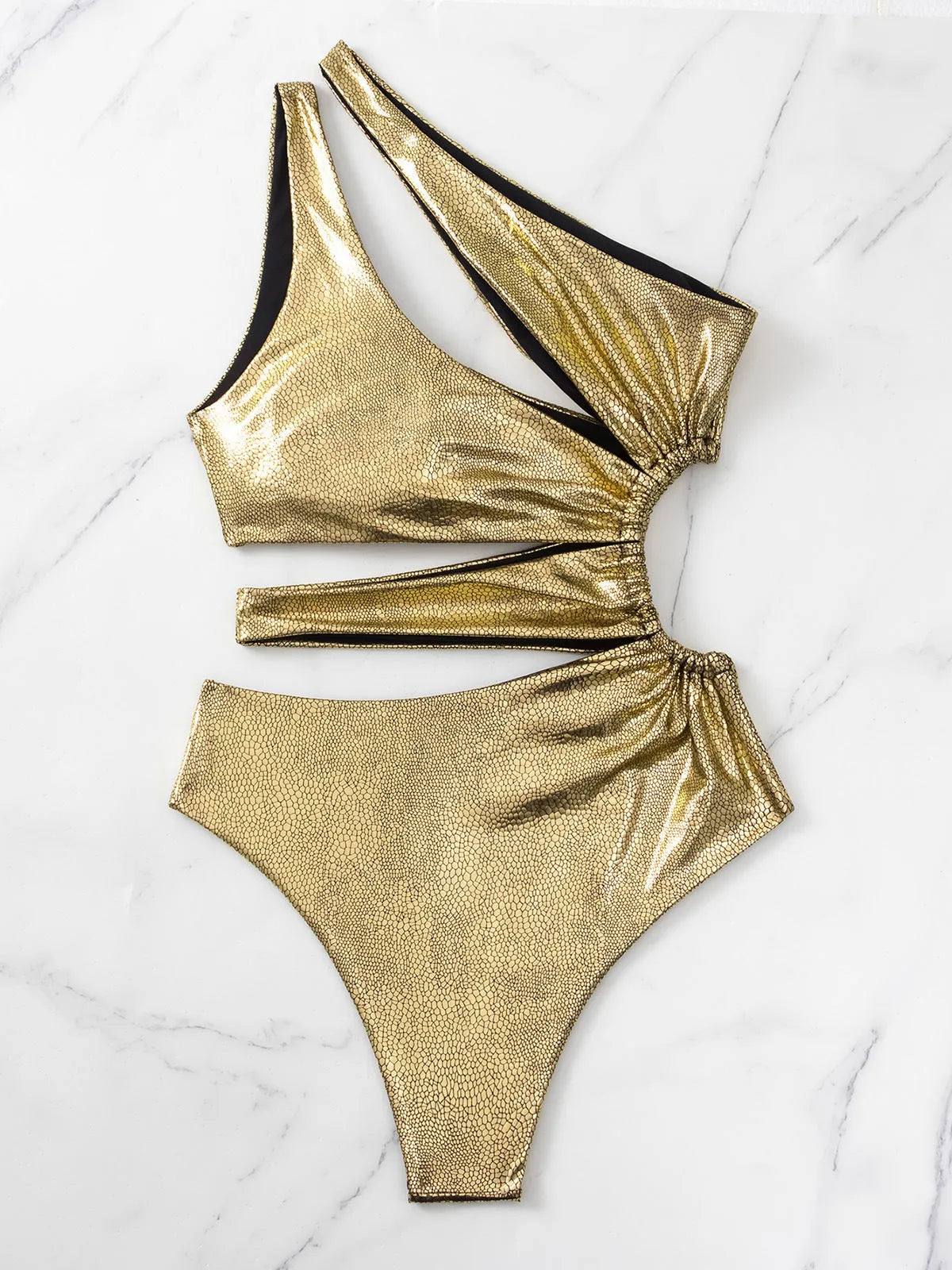 Women's gold backless one-piece swimsuit on a white background