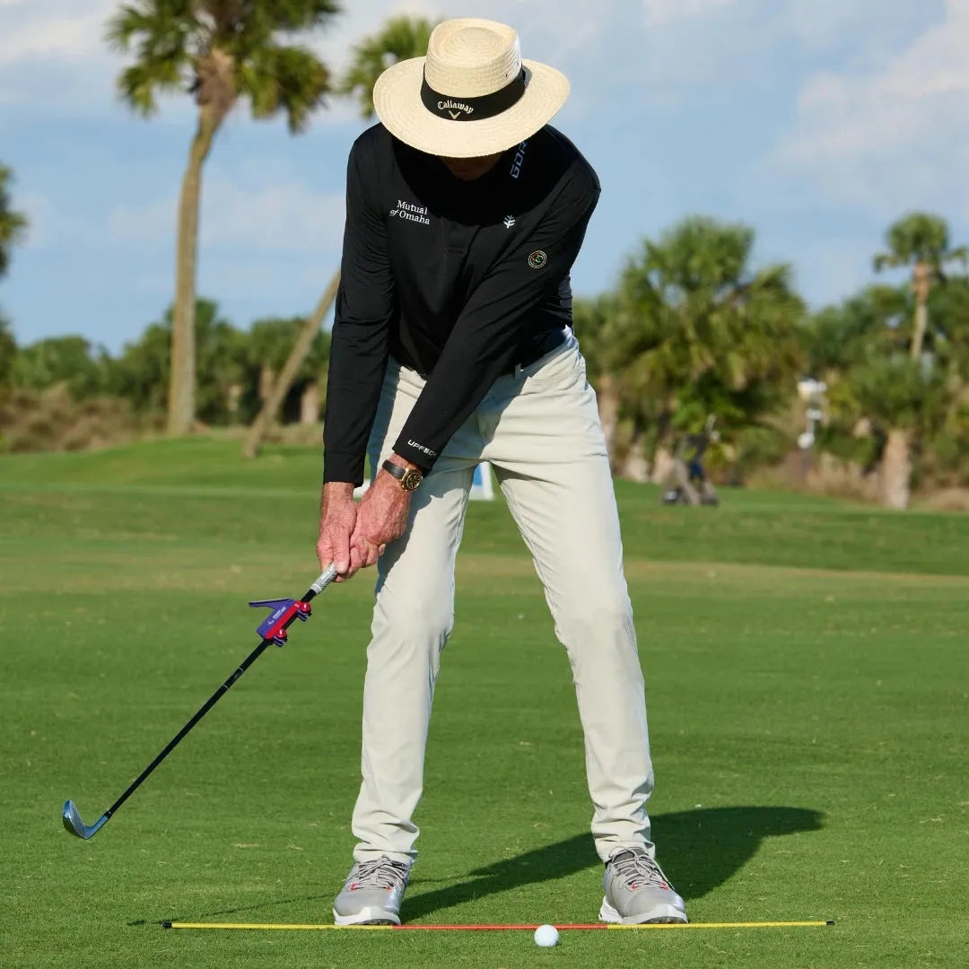 Plastic golf swing plane simulator trainer on practice surface