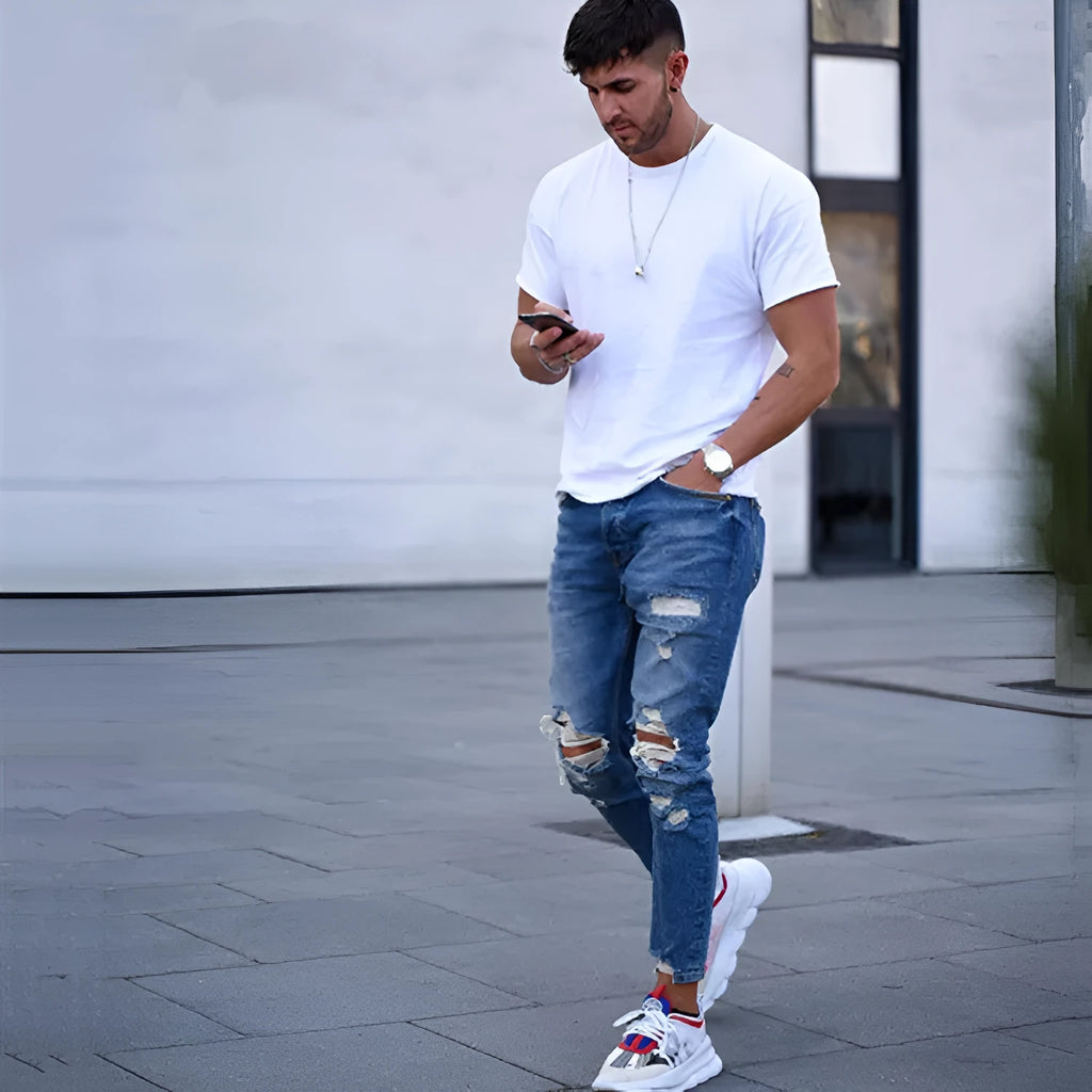 Men's deep blue ripped jeans with distressed hole detailing in 100% cotton fabric