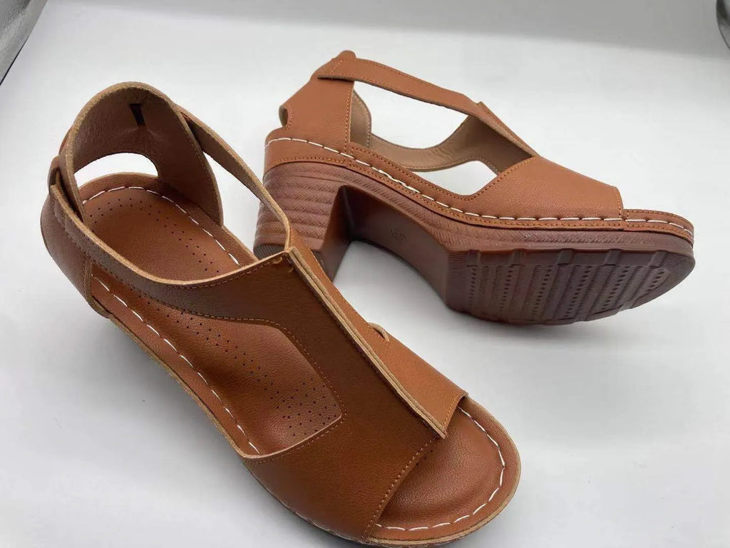 Women's beige peep toe wedge sandals with an adjustable ankle buckle strap on a foot.