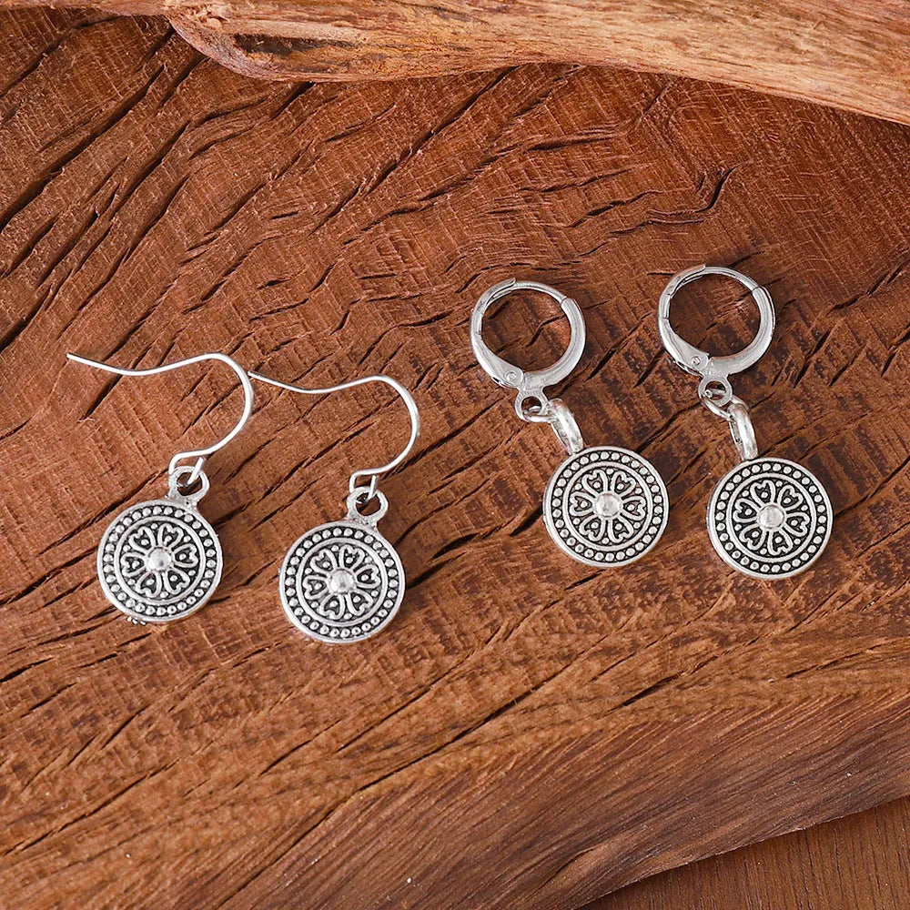 Close-up of a pair of distressed geometric bohemian earrings with a round print, in zinc alloy with electroplated colour.