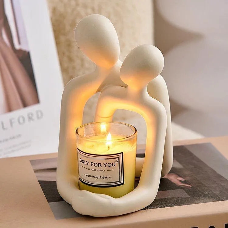 Modern couple resin statue in gold finish on a wooden desk.