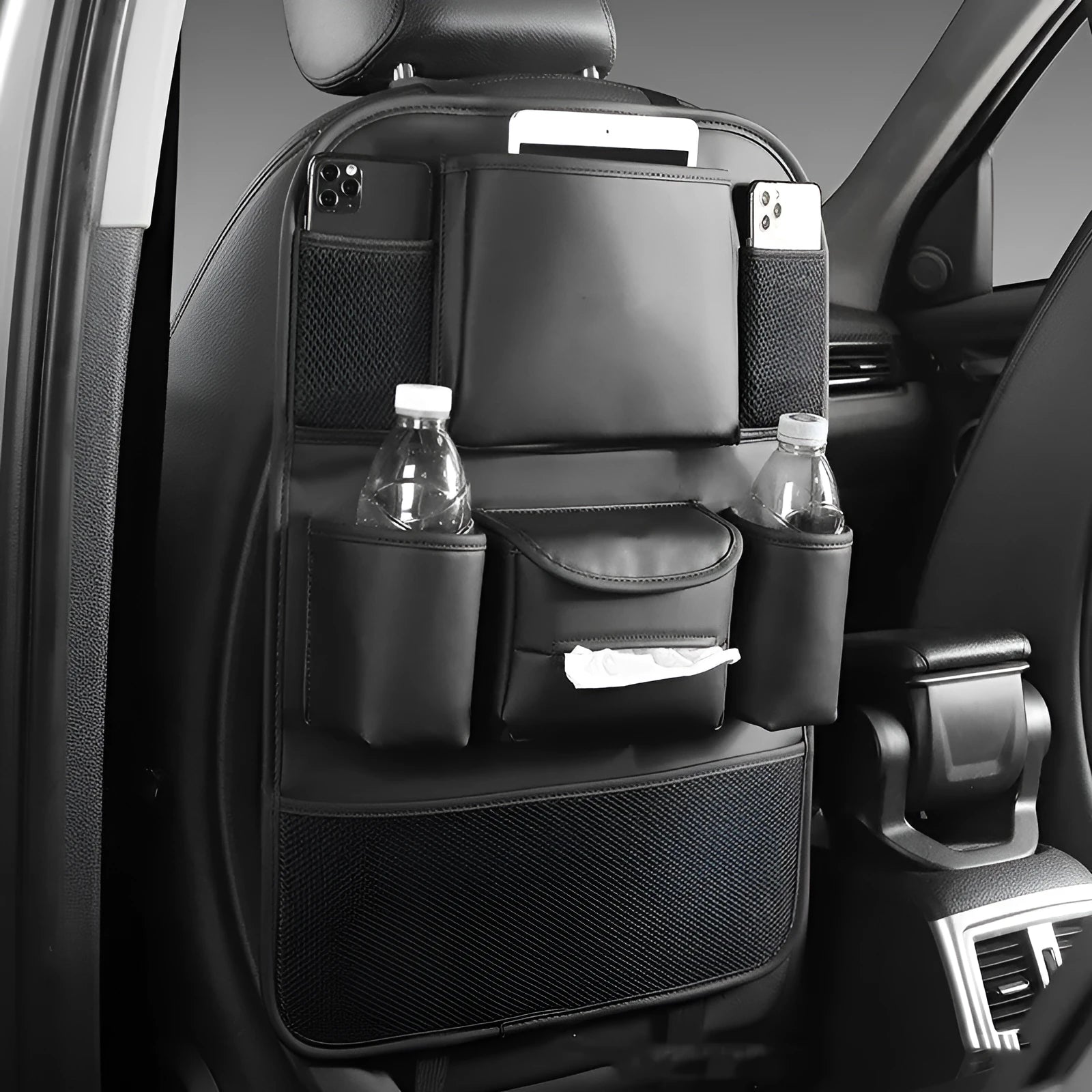 A leather car seat back storage bag hanging behind a vehicle seat.