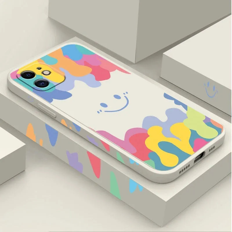 White TPU iPhone case with rainbow smiley faces on top and bottom, includes a black lanyard.