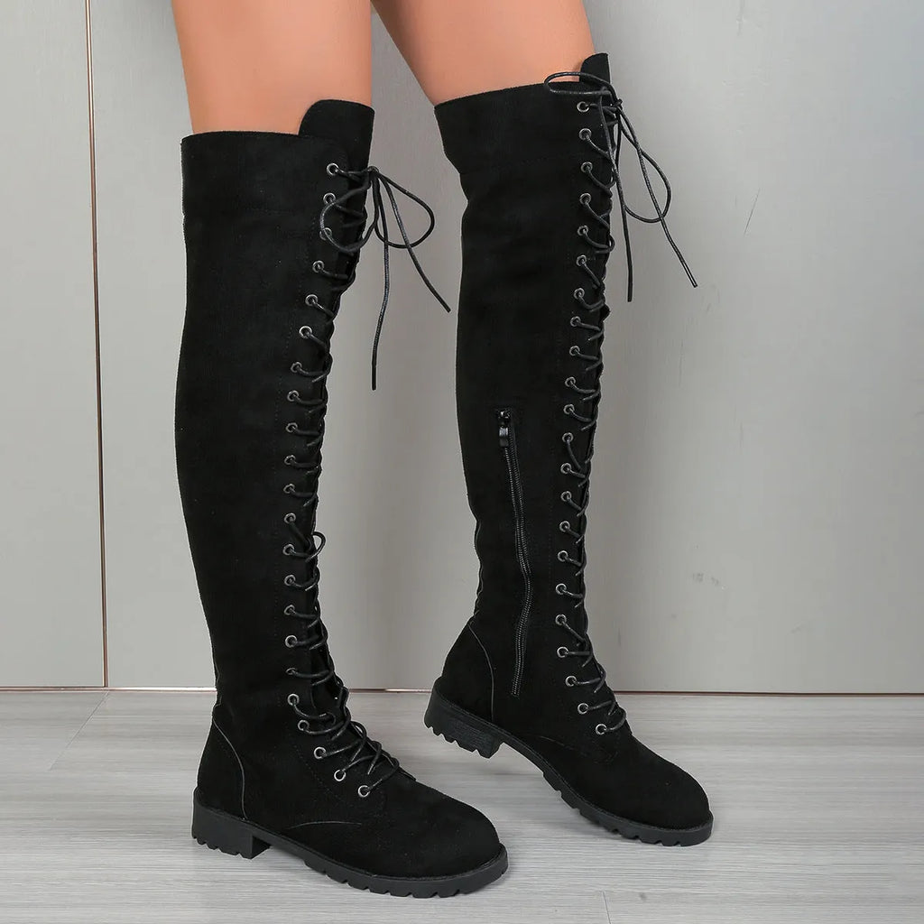 Black women's lace-up over the knee boots with round toe and flat rubber sole on a neutral background.
