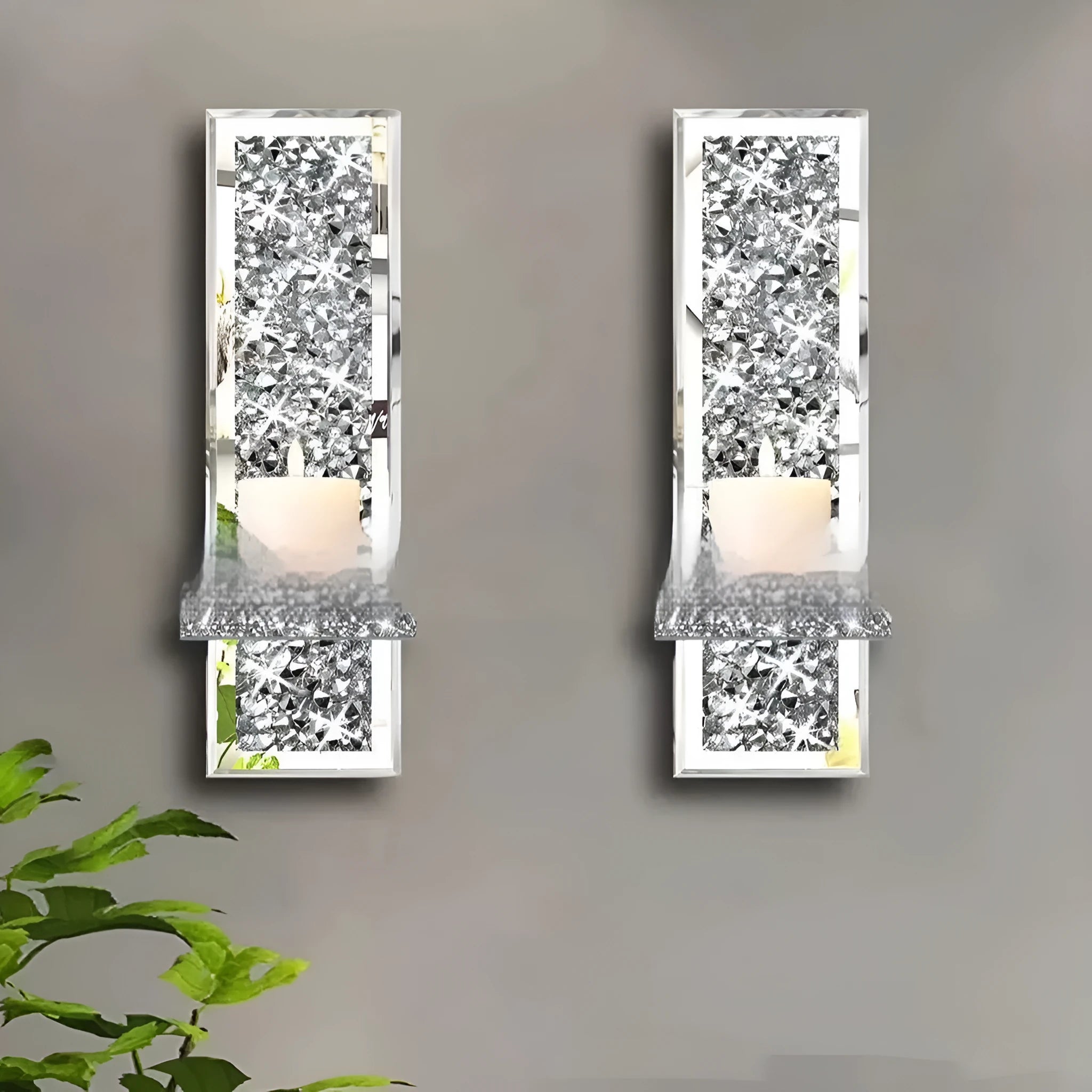 A pair of tall silver mirror glass candle holders designed for wall mounting