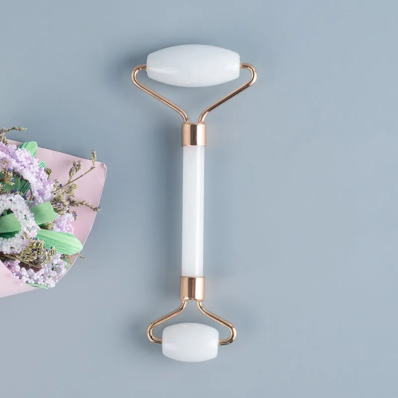 Natural white jade double-headed facial roller and matching scraping board set on a flat surface.