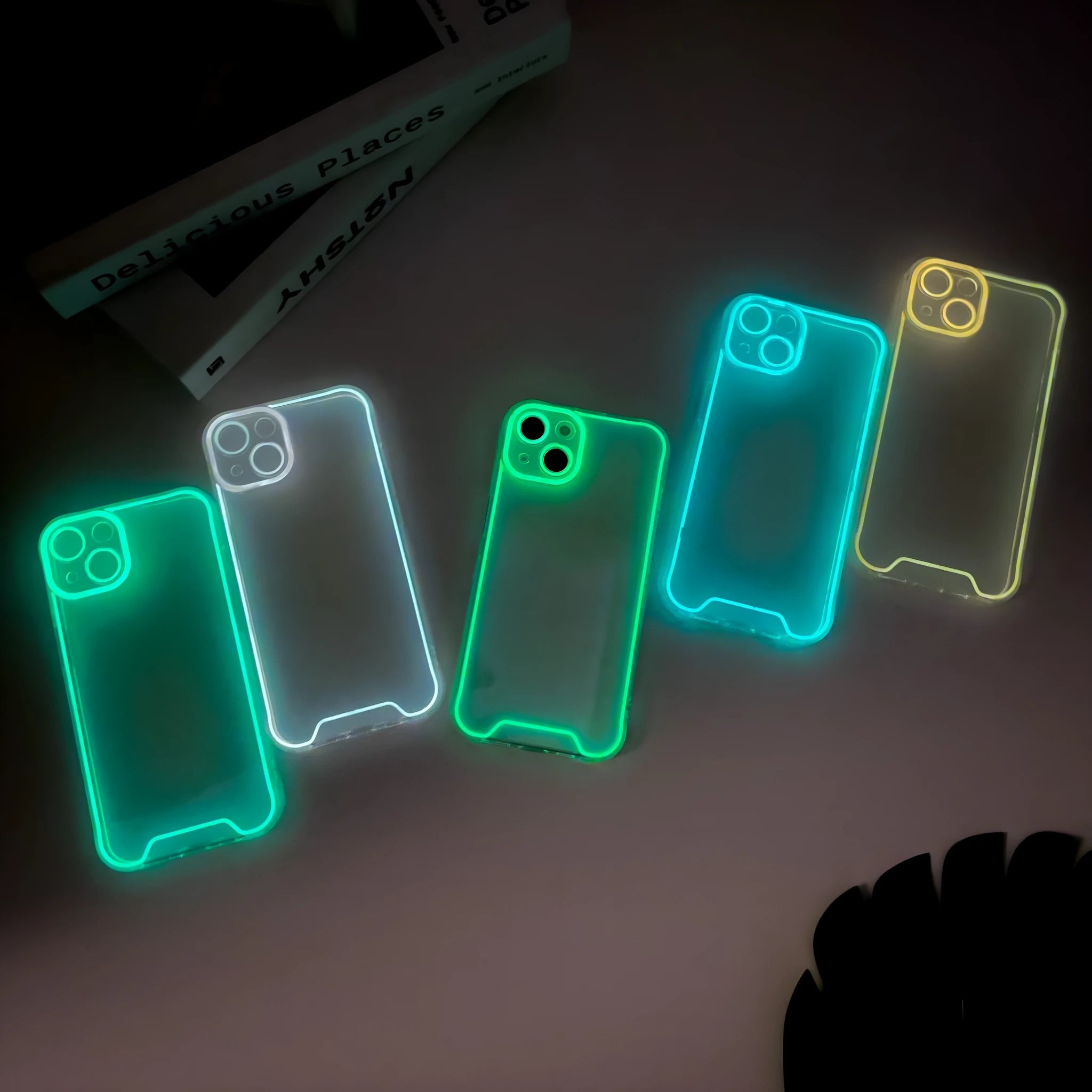 Glow in the dark Christmas phone case for iPhone in green, orange, blue, yellow, and pink colours.