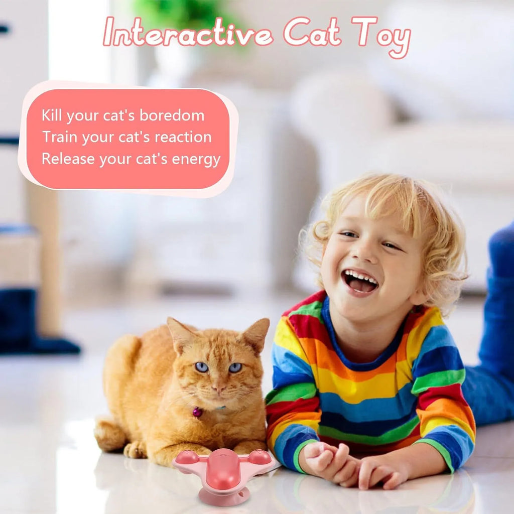 Interactive pet puzzle toy with blue base, a central snack cabin, a bell, and catnip attached. Shows suction cups on bottom.