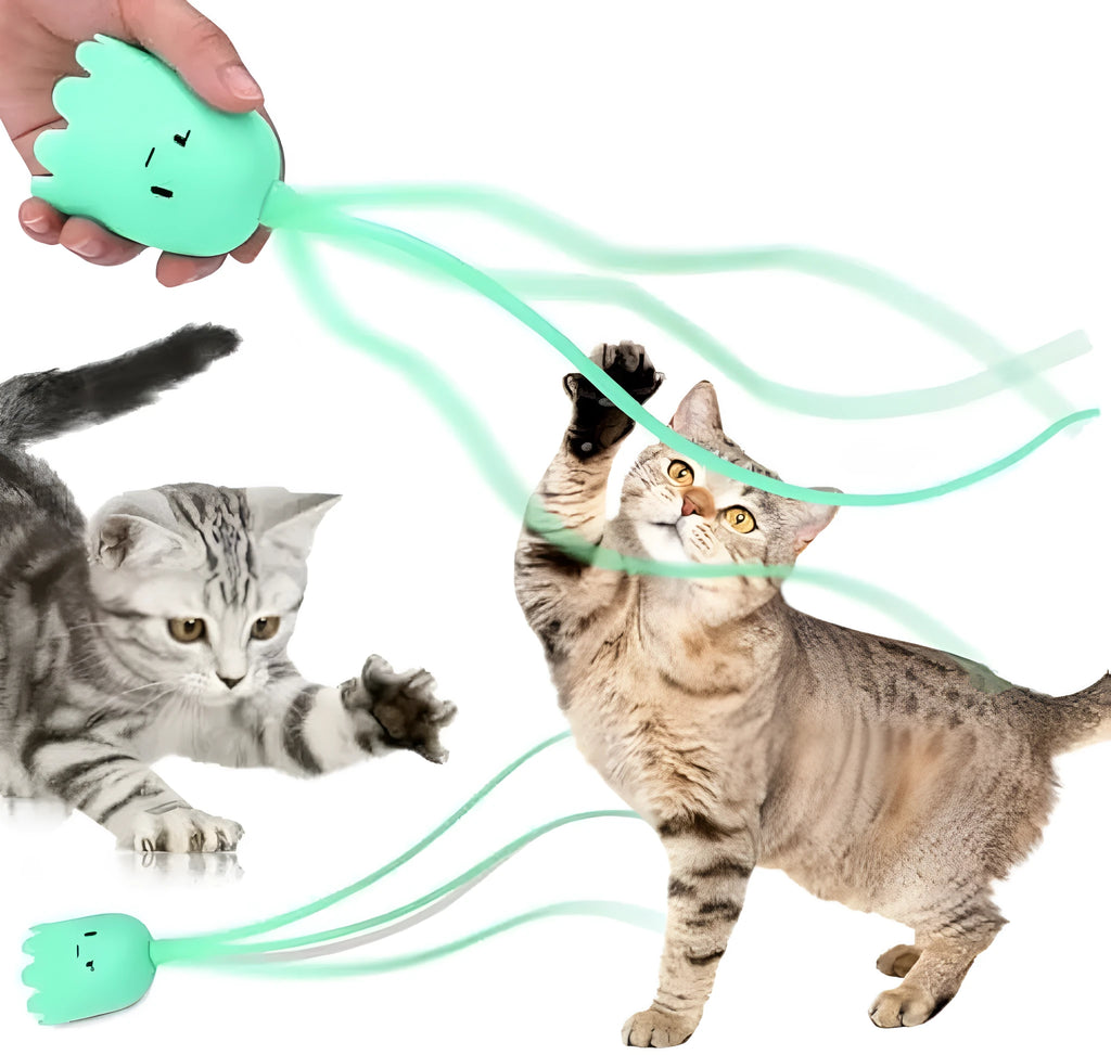 Green automatic electronic cat wand toy with swinging silicone tails on a table.