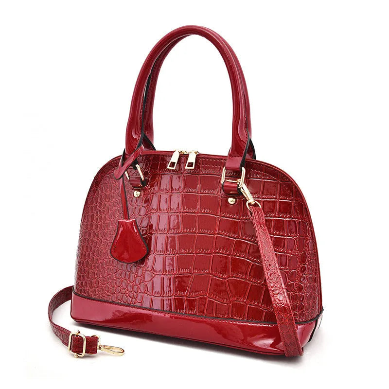 Large shiny black PU leather crossbody shoulder bag showing shell-shaped structure.