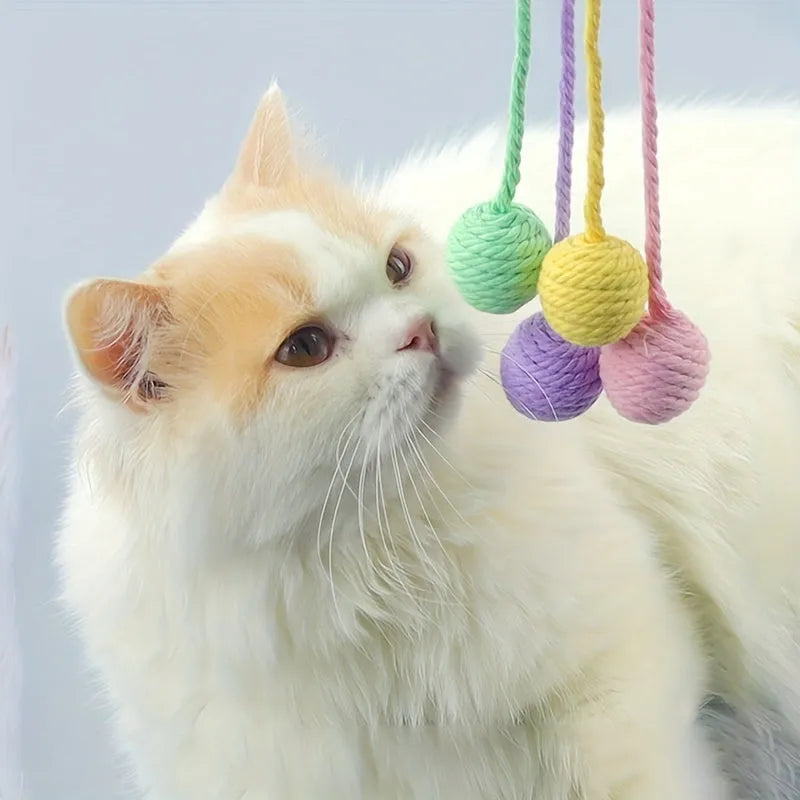 Green cat toy ball with a rope handle looped through it, shown next to a smaller pink version.