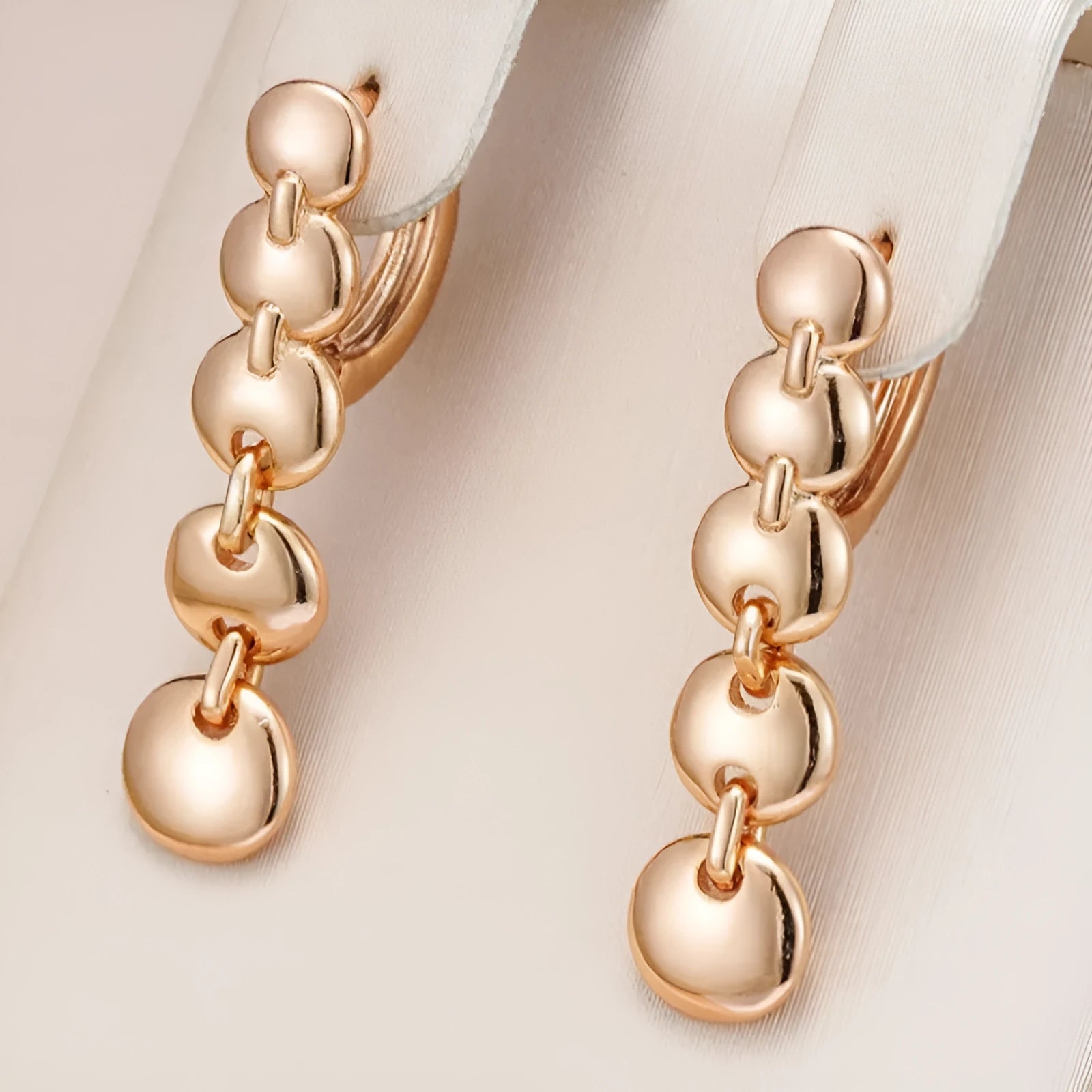 Gold tone retro earrings with a round circle shape and surface weave design, hanging as a dangle.