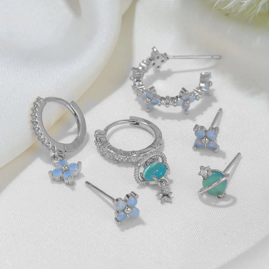 Gold and silver floral stud earrings with blue protein flower nail and zircon mosaic detail.