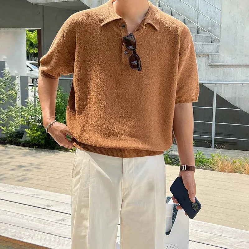 Man wearing a caramel-coloured loose-fit knitted polo shirt with short sleeves and an asymmetrical design detail.