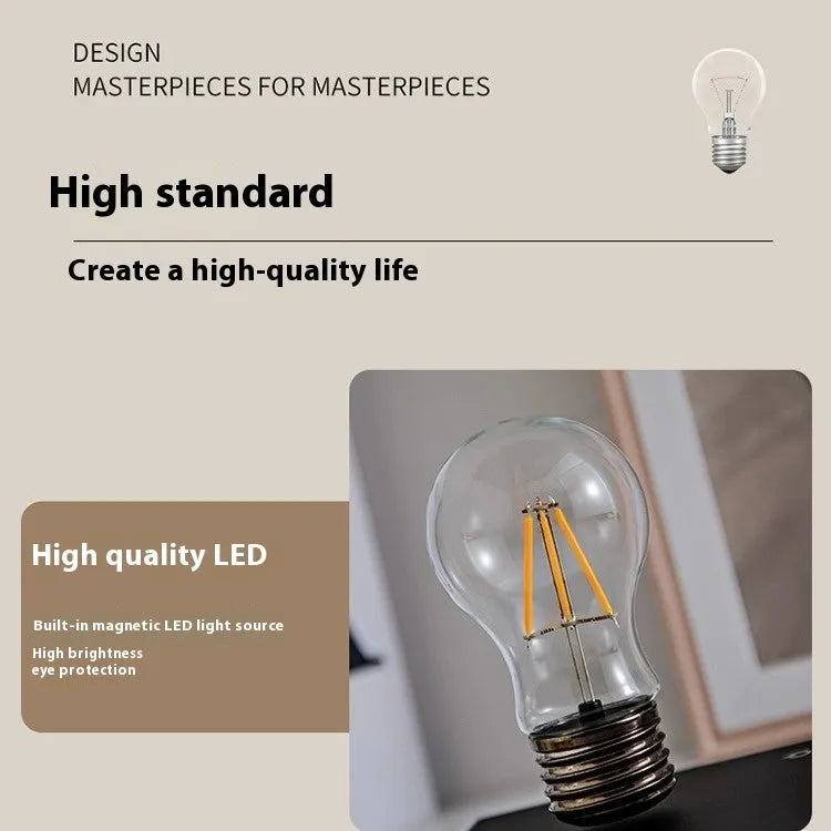 Creative small iron art night lamp with suspension bulb design on a black wood grain base.