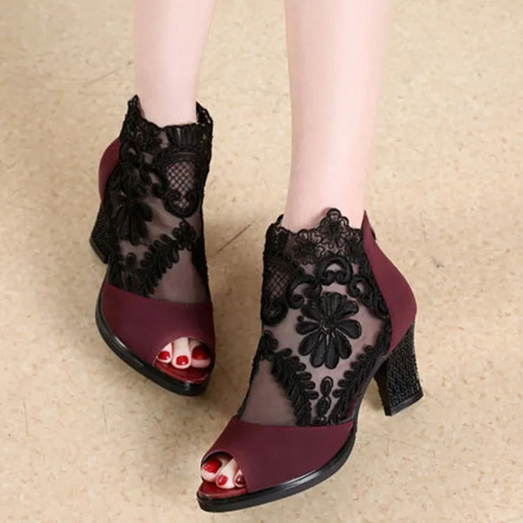 Women's black gladiator sandals with square heels and flower lace upper showing zip closure detail