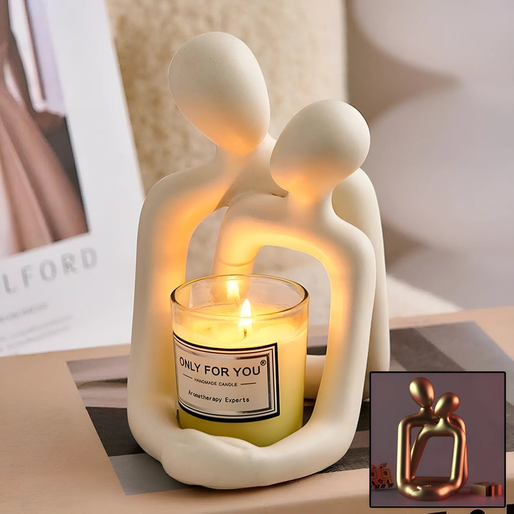 Modern couple resin statue in gold finish on a wooden desk.