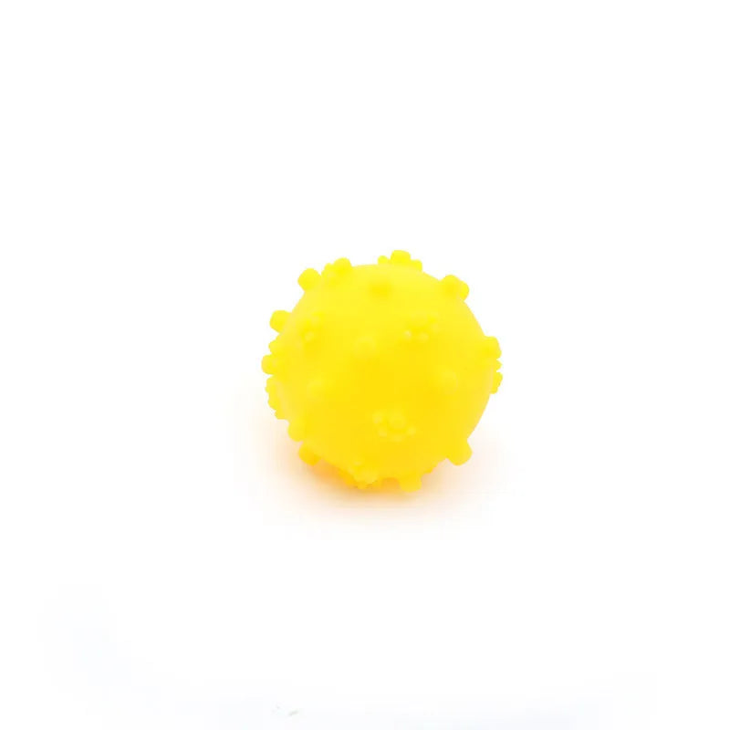 Bright coloured spiked squeaky balls for small dogs on grass