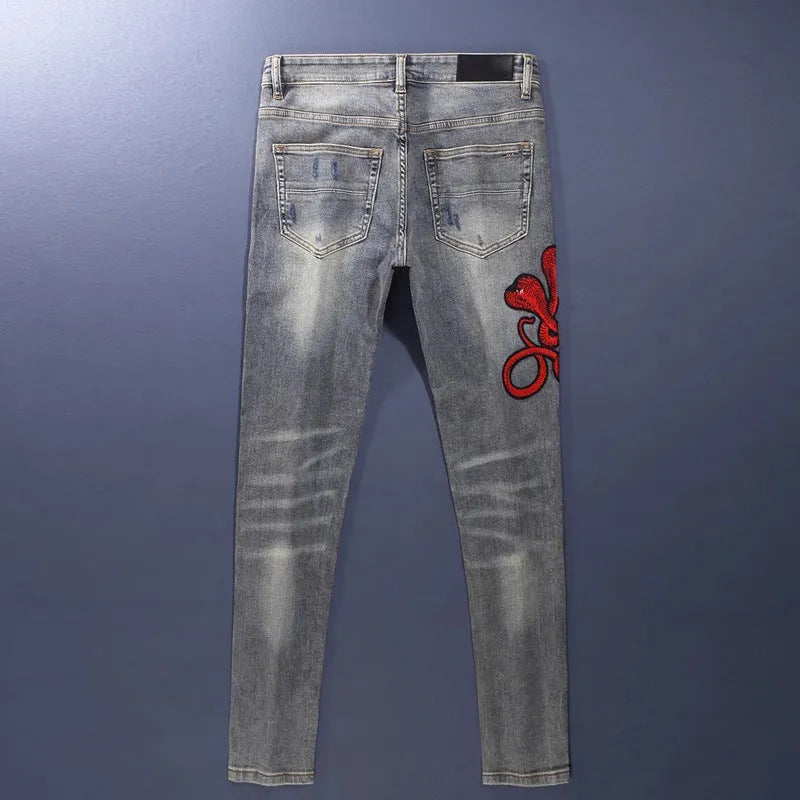 Distressed slim fit jeans with embroidered patches and washed-out vintage colour