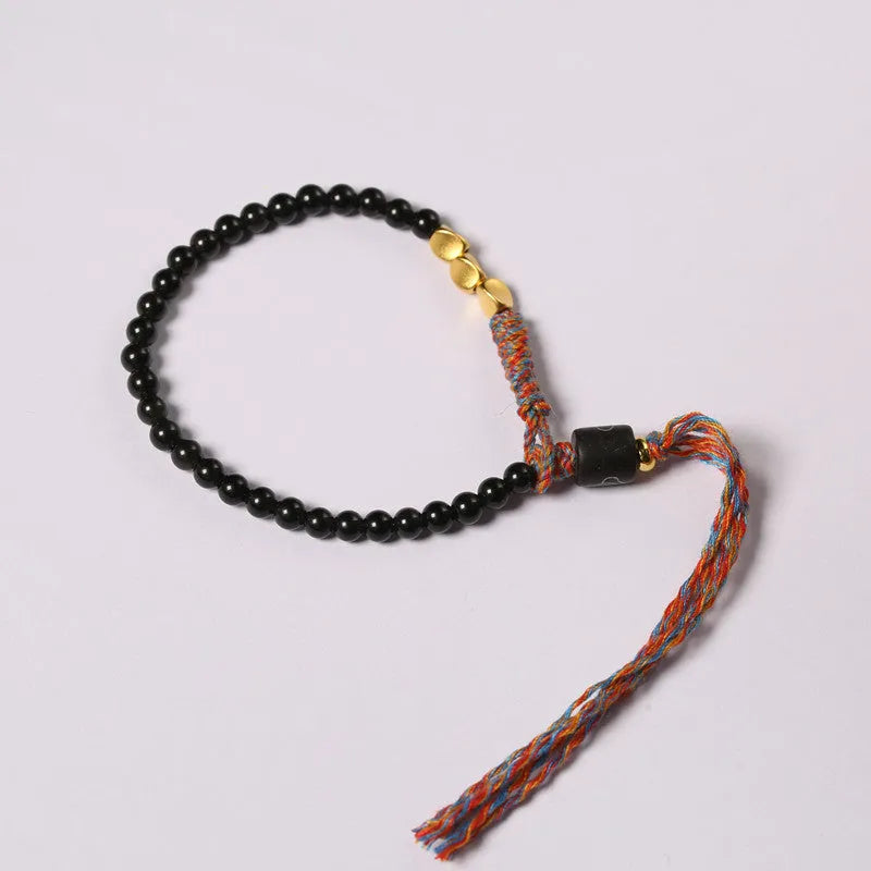 Hand-woven obsidian carrying strap bracelet showing textured surface and dark colour