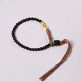 Hand-woven obsidian carrying strap bracelet showing textured surface and dark colour