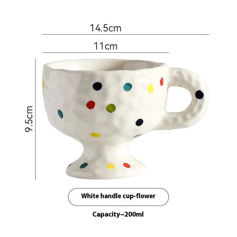A handmade, irregularly shaped ceramic mug in a solid colour, shown on a table.