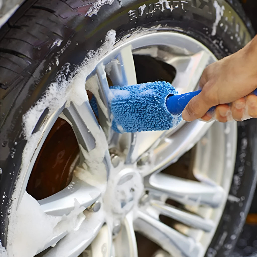 Blue long-handled microfiber brush for cleaning car tyres and wheels on a grey background.