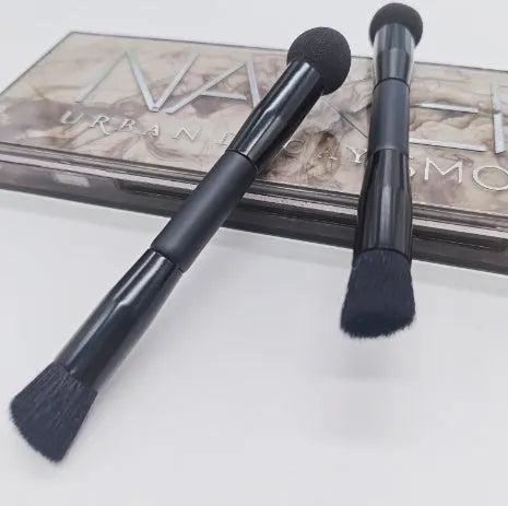Elegant black double-headed makeup brush with a concealer brush and angled miter sponge on a wooden handle.