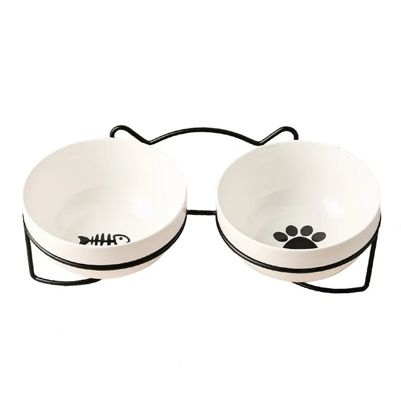 White ceramic cat food bowl with cat paw print design on black iron frame stand