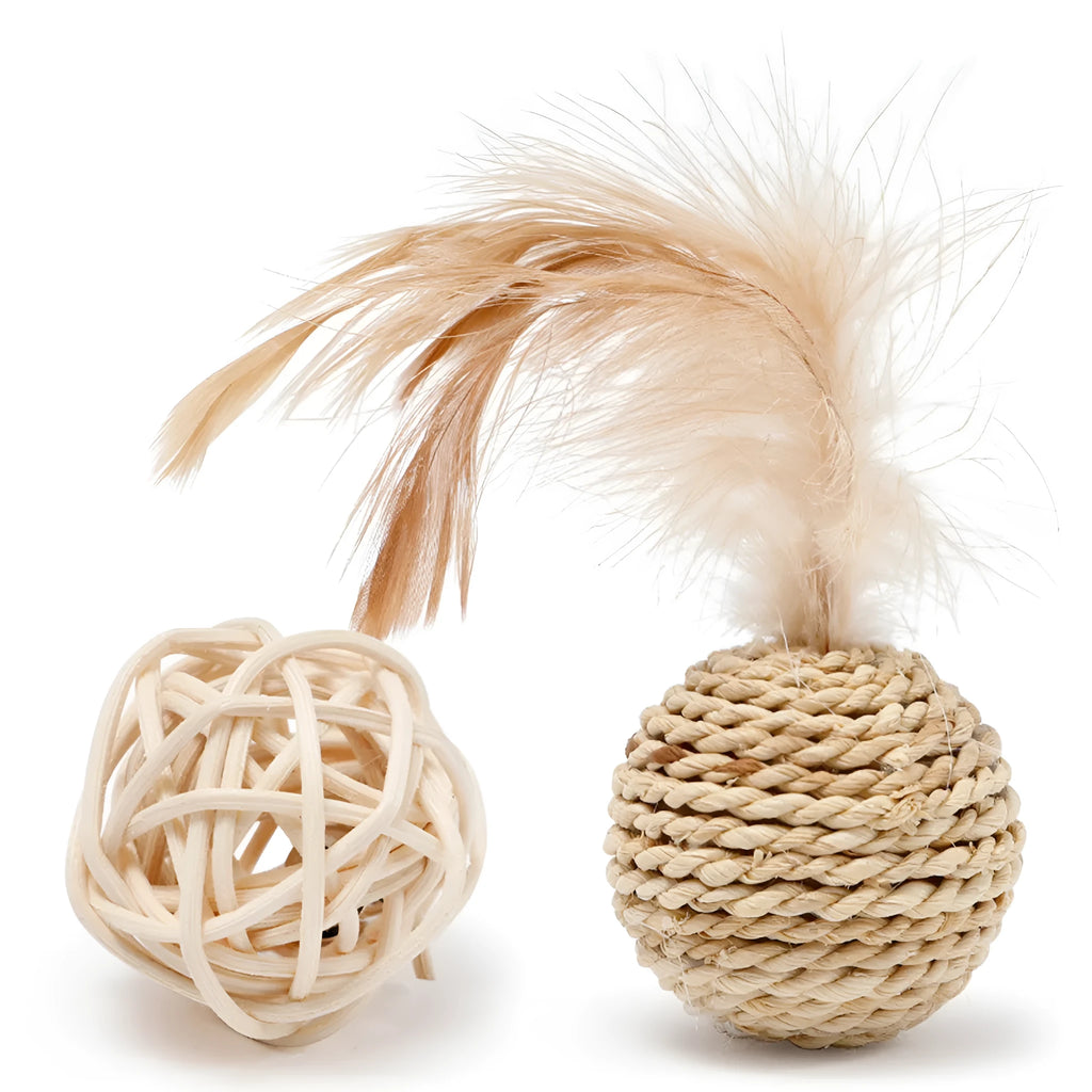 Two cat toy balls: one rattan sphere and one colourful faux feather ball with bell on a neutral background