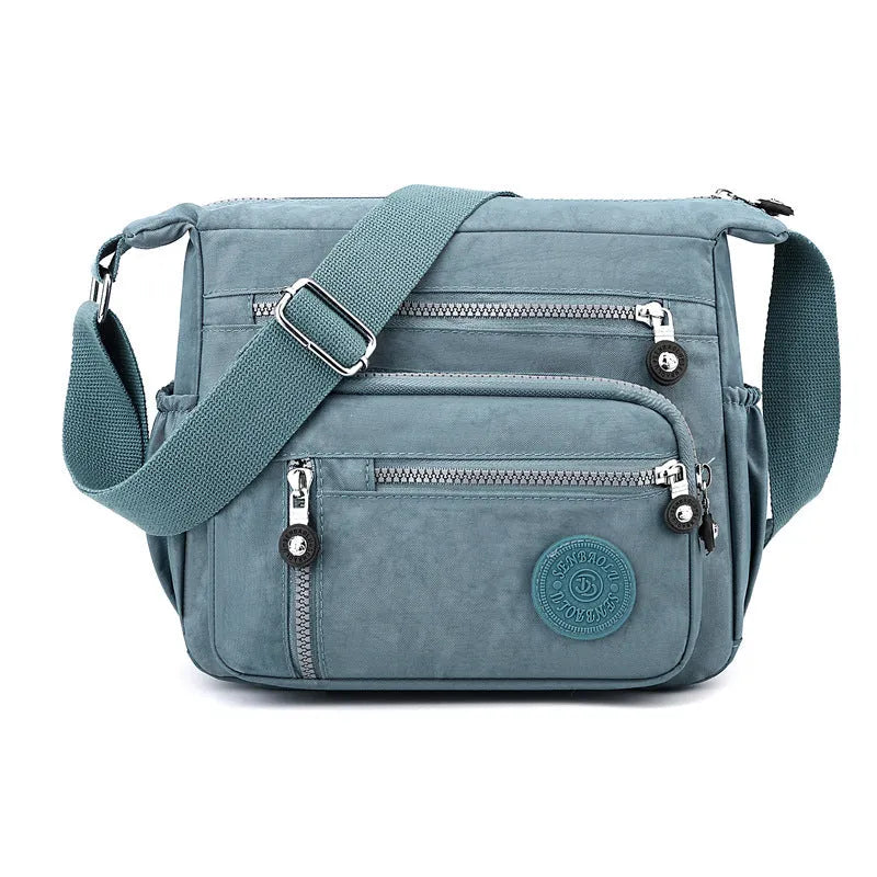 Soft nylon messenger bag in grey, shown as a square vertical model with a single shoulder strap.