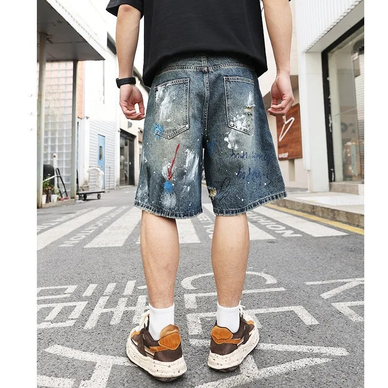 Blue ripped men's denim shorts with graffiti design and zipper fly