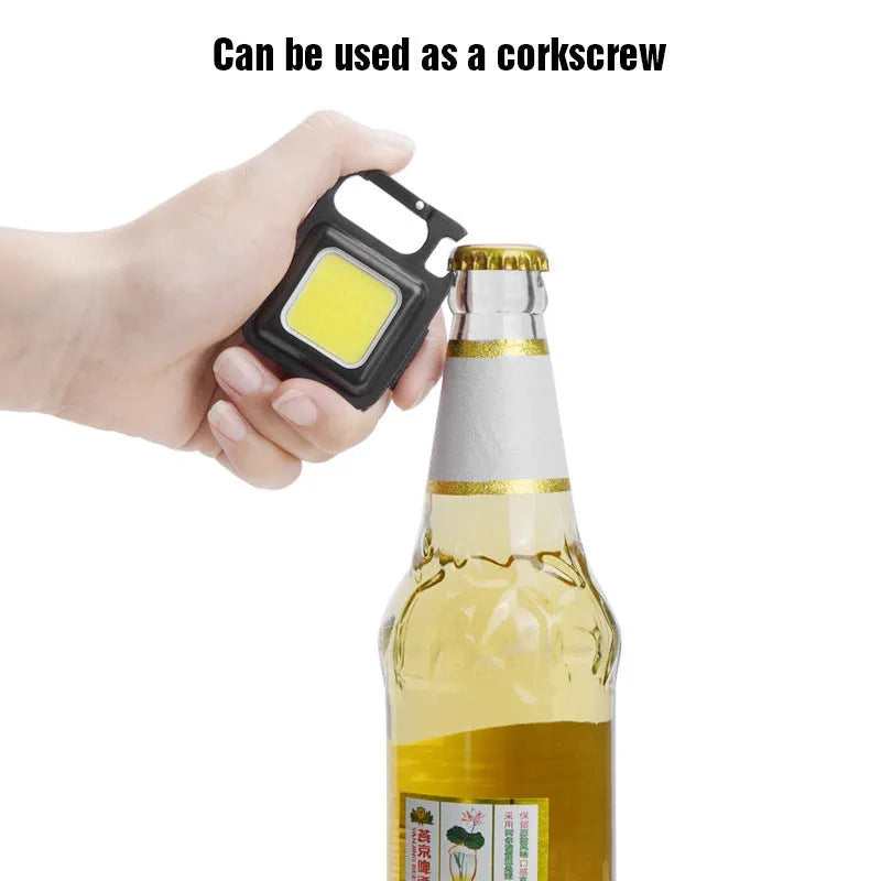 Black aluminium alloy USB rechargeable keychain light with LED, magnet, and folding handle