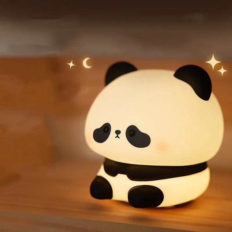 Cartoon panda-shaped silicone night light for kids on a bedside table.